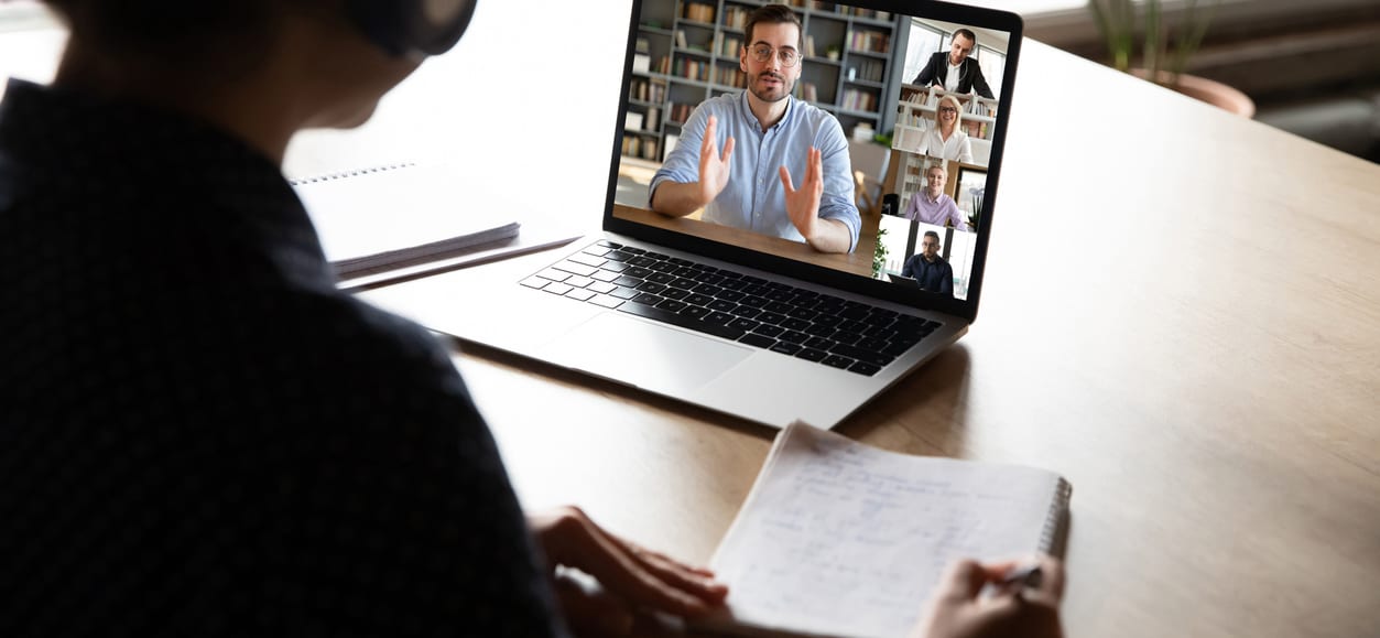 Persoon achter een laptop tijdens een online sessie met meerdere deelnemers — illustratie bij de Cultuurconnectie-rollout van Zoom voor cultuureducatie.