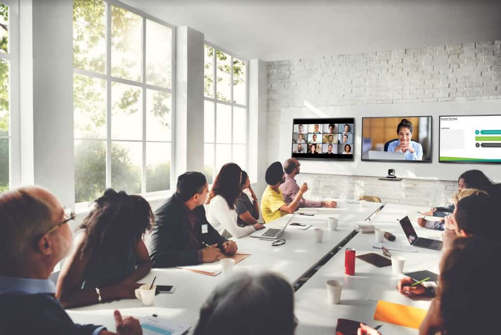 Hybride boardroom met Zoom Rooms-installatie, camera die de zaal opvangt, deelnemers op scherm.